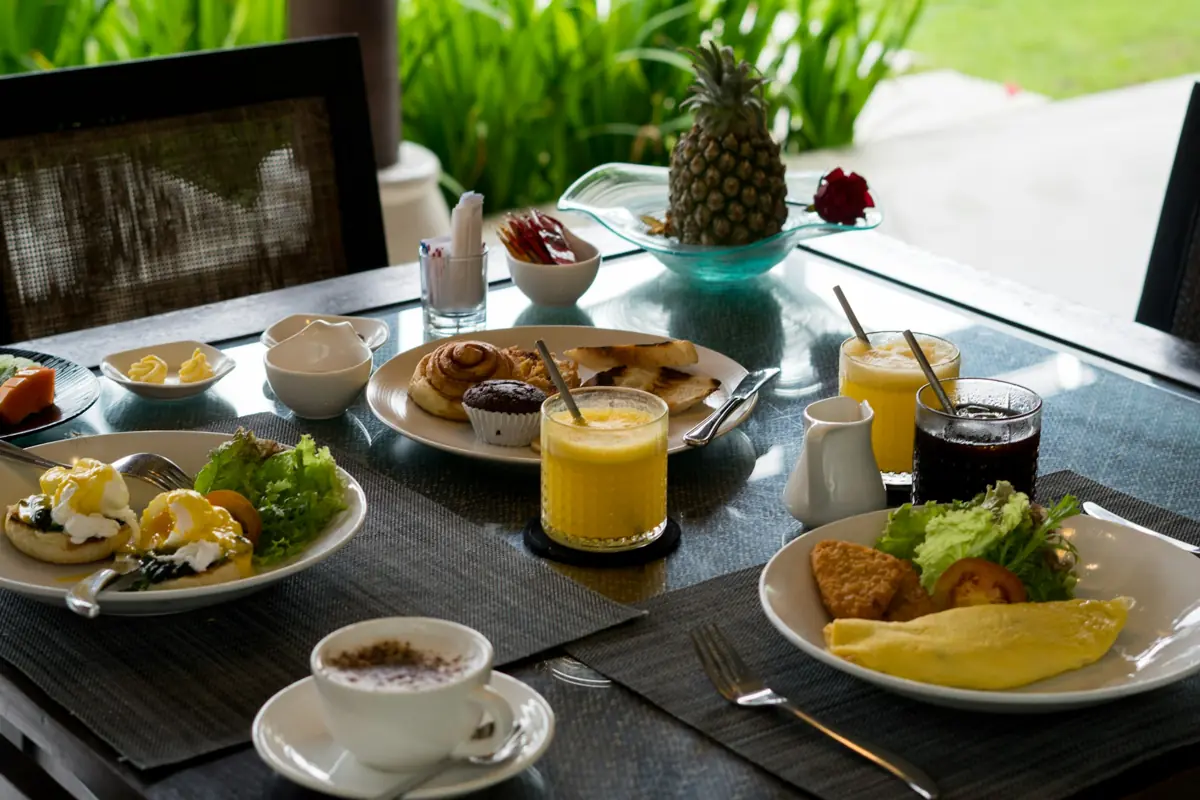 Breakfast served at a hotel table: eggs, pastries, fruit and coffee