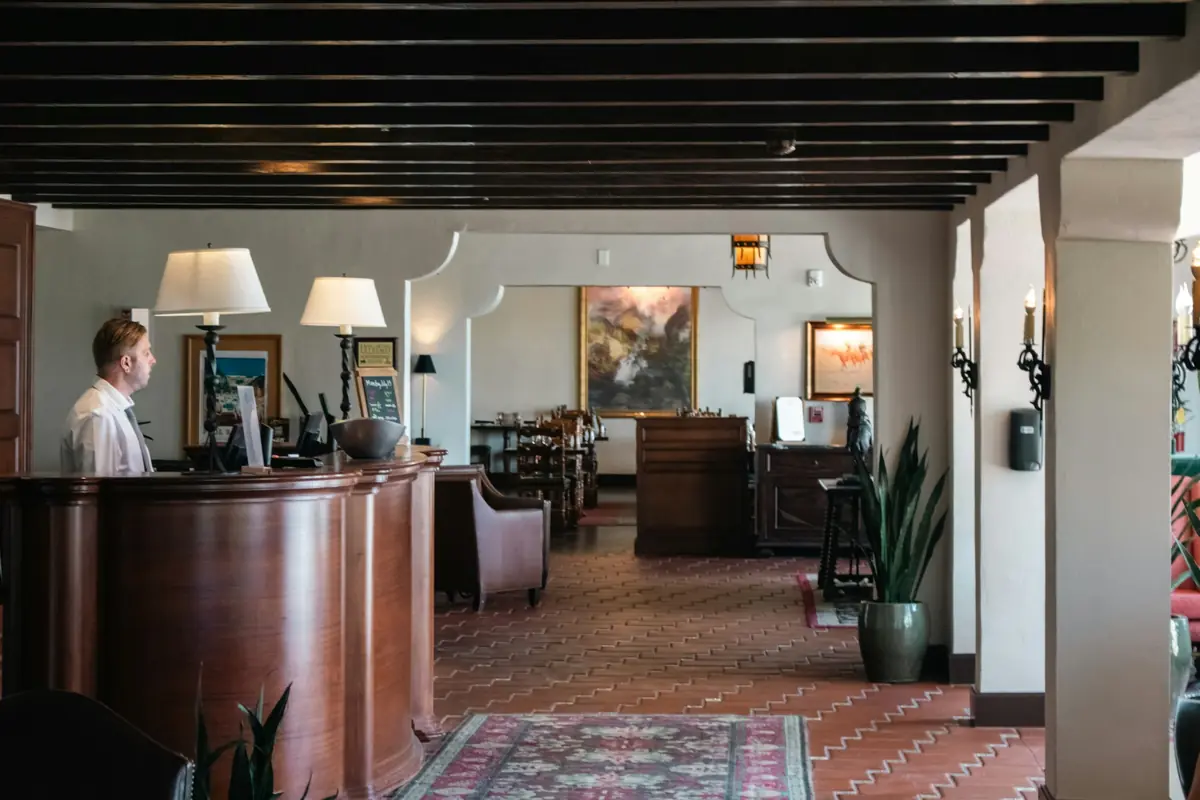 A staff member at the front desk of a small hotel