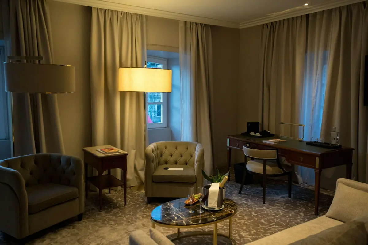 A hotel room with armchairs, a desk and soft daylight